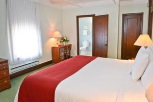 King room with bed and bathroom viewed through open door.