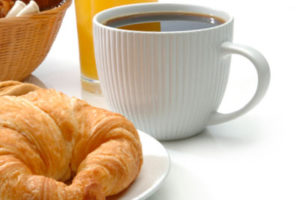 A cup of coffee with a pastry